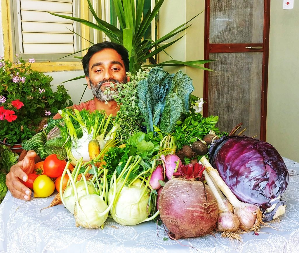 Nasser Rego hugging vegetable harvest. Home gardening in the Middle East